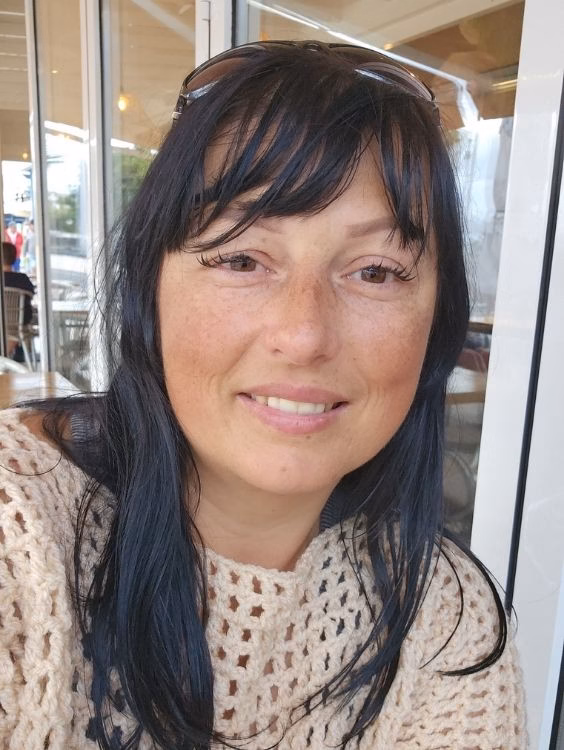 C2C crochet designer Ariana Wimsett smiling at the camera. Wearing one of her crochet designs.