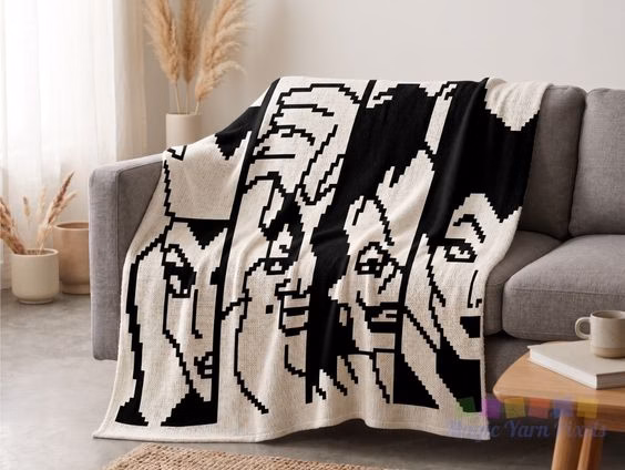 A black and white C2C crochet blanket draped over a gray sofa in a cozy living room setting, next to a small wooden side table holding a white mug and a book. The blanket features pixelated designs of four villains: the Evil Queen, Ursula, Cruella de Vil, and Maleficent. The Magic Yarn Pixels watermark is visible in the bottom right corner. This is part of a crochet roundup from https://magicyarnpixels.com/.