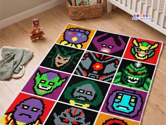A corner-to-corner (C2C) crochet blanket displaying a twelve-panel grid of colorful pixel art style blocks depicting various Avengers villains, laid out on a light wood floor in a nursery room next to a white wooden crib. Original design by Ariana of MagicYarnPixels.