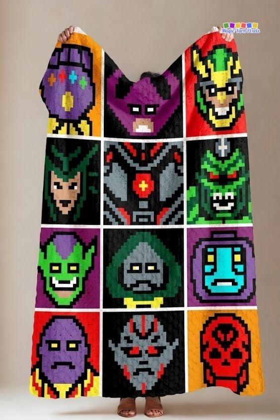 A person holding up a corner-to-corner (C2C) crochet blanket featuring a grid of twelve different pixel art panels representing various Avengers villains, highlighting the full vertical design. Original design by Ariana of MagicYarnPixels.