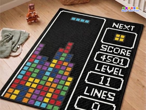 Retro Arcade Blocks C2C crochet blanket displayed on a nursery floor, featuring colorful pixel blocks and a retro game-inspired score panel on a black background. Original design by Ariana of MagicYarnPixels.