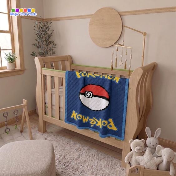 Pokémon card-inspired C2C crochet blanket draped over a wooden crib, featuring a large Poké Ball motif, yellow pixel lettering, and a navy blue background in a nursery setting. Original design by Ariana of MagicYarnPixels.